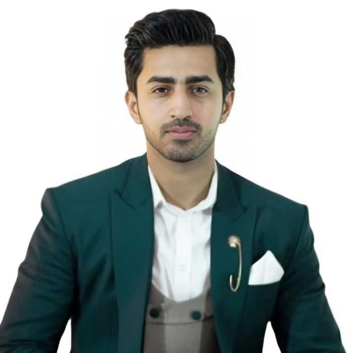 Portrait of Malik Hamza Javed in a dark green suit